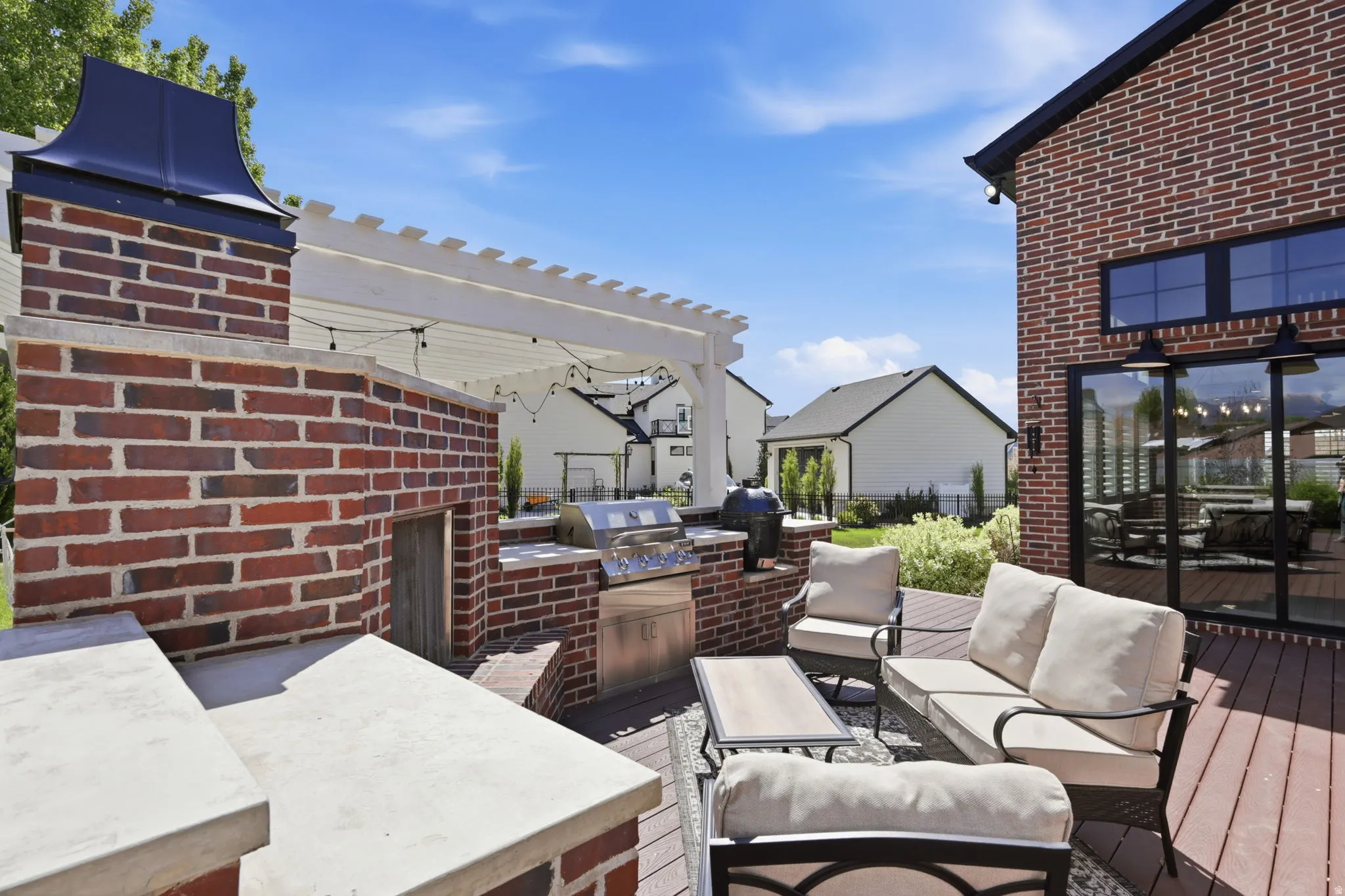 Wooden terrace featuring an outdoor kitchen and area to lounge and a pergola