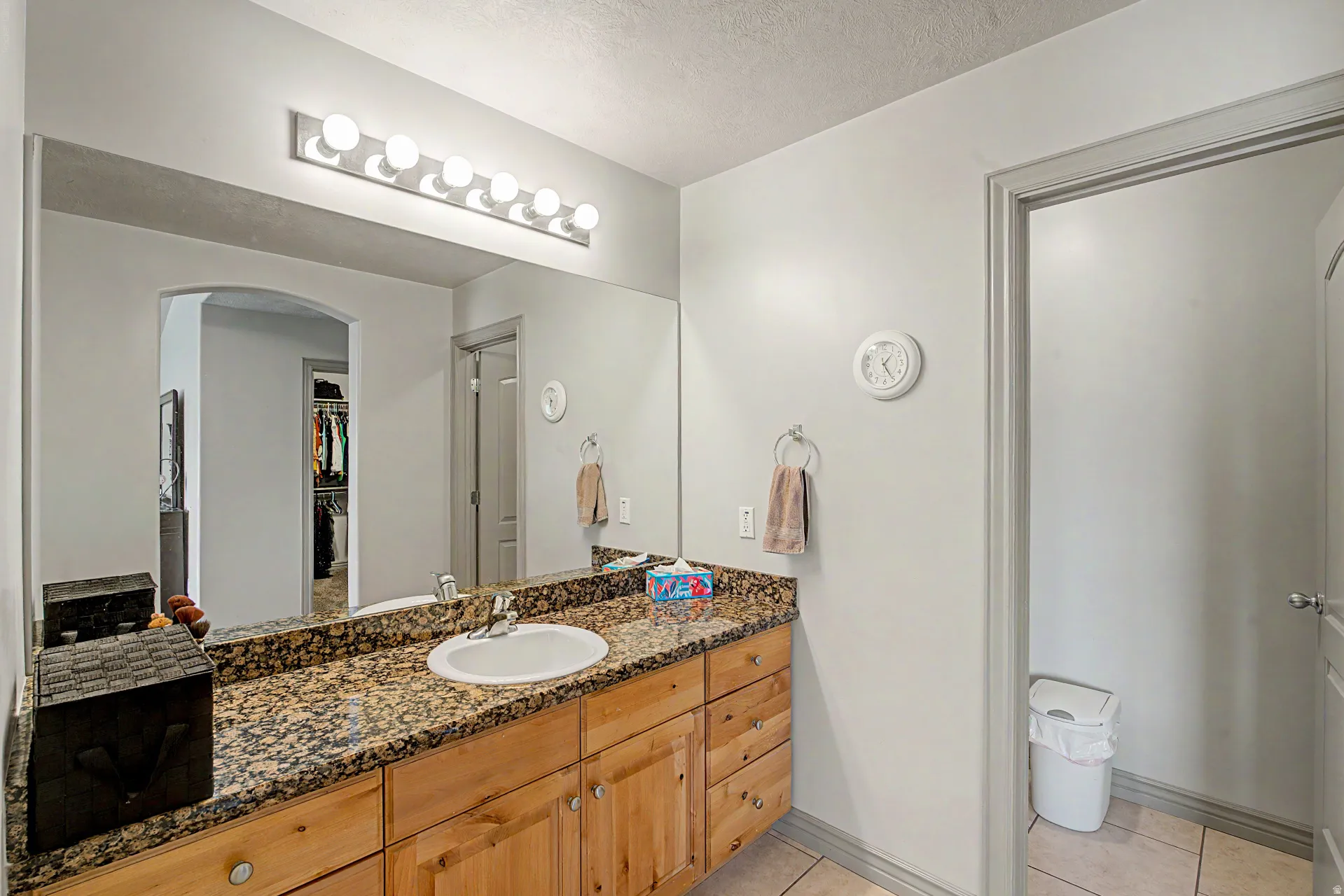 Full hall bathroom featuring vanity, light tile patterned flooring,