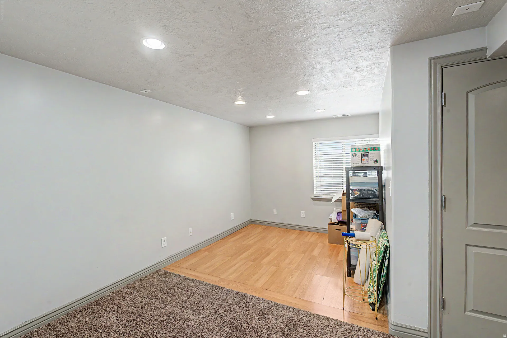 Flex room featuring a textured ceiling, recessed lighting, and light wood finished floors