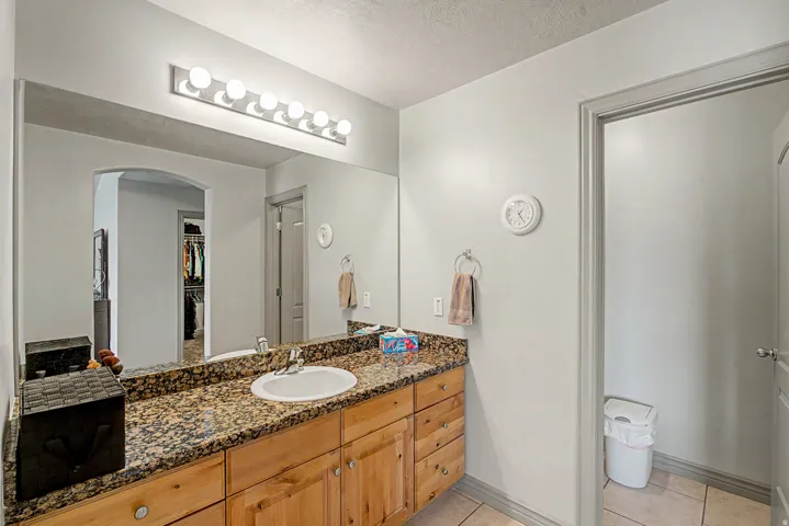 Full hall bathroom featuring vanity, light tile patterned flooring,