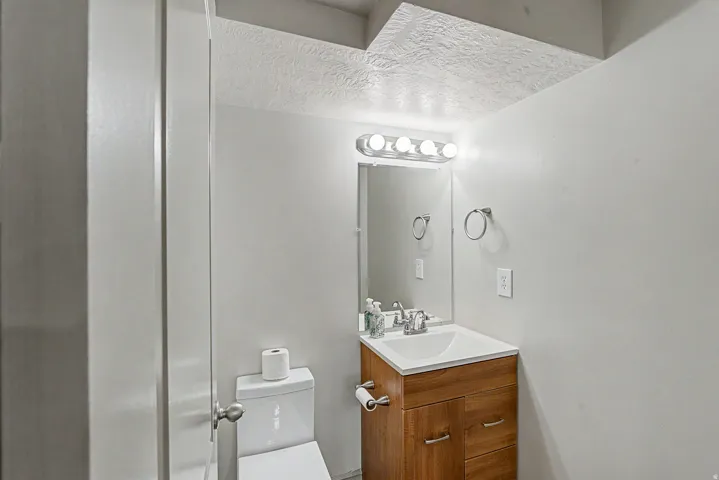 Half bath featuring vanity with mirror and updated lighting fixture