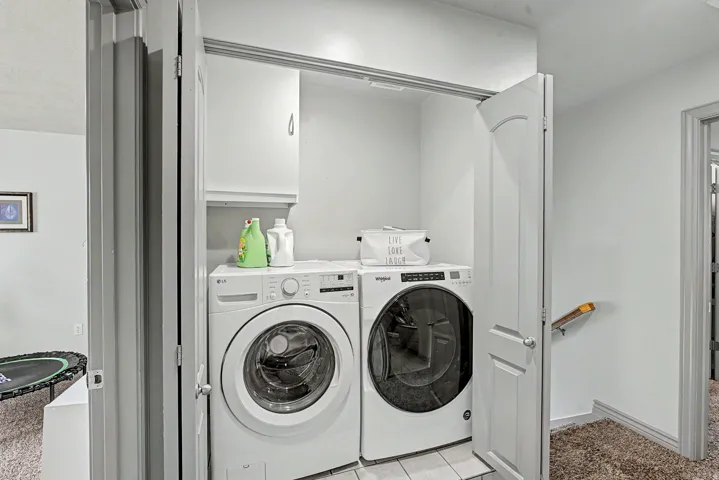 Laundry area with washer and clothes dryer and baseboards