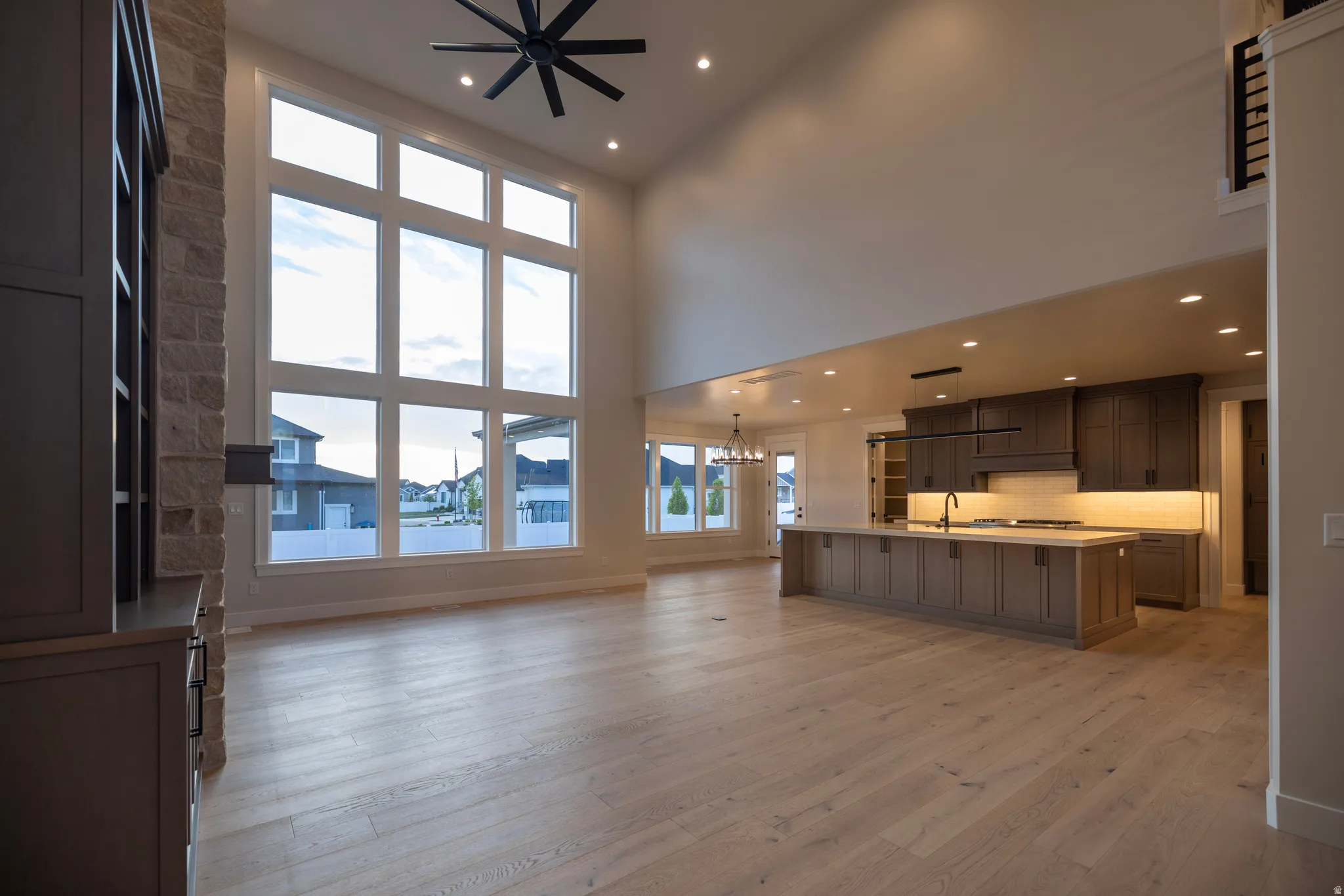 Unfurnished living room with hanging lights, and a high ceiling