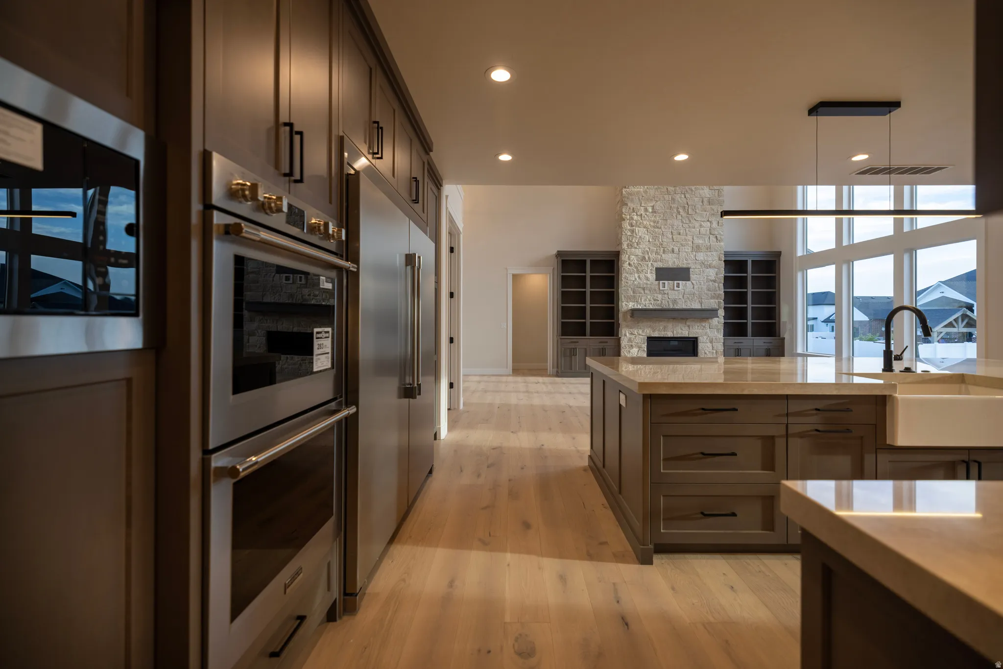 Kitchen featuring stainless steel appliances, light tiled finished floors, open floor plan, and dark wood finish cabinets