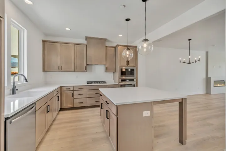 Kitchen with a center island, light wood-style floors, stainless steel appliances, and a fireplace