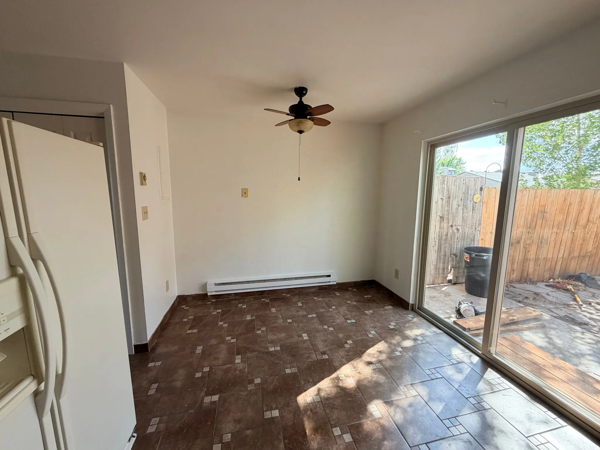 Unfurnished dining area with ceiling fan and a baseboard radiator