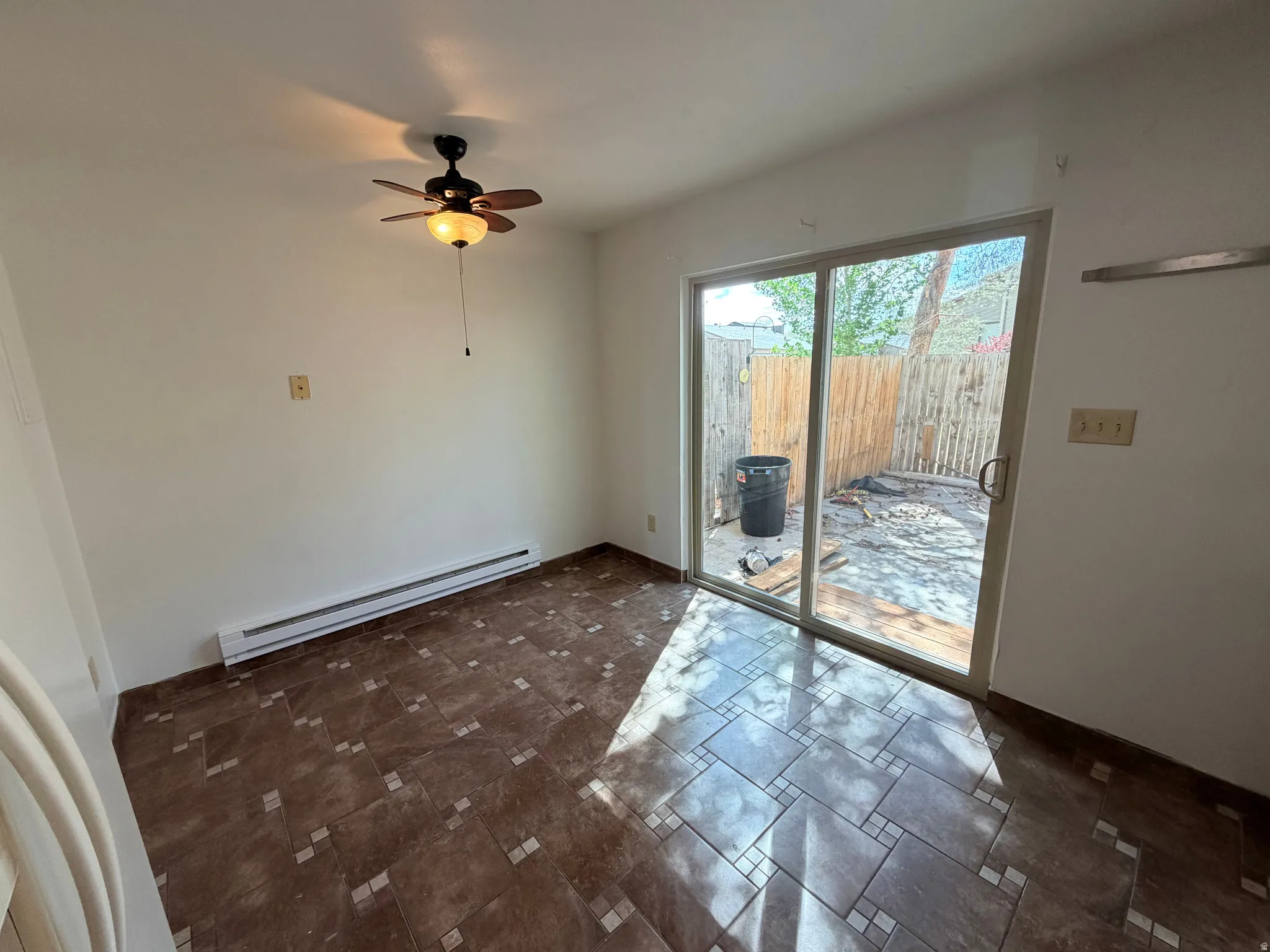 Unfurnished dining area featuring a baseboard radiator and ceiling fan