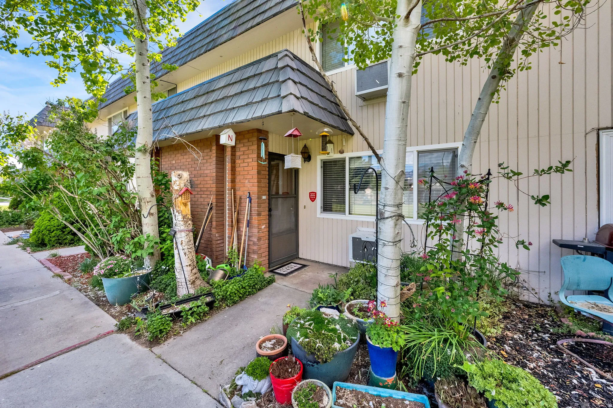 Property entrance featuring mansard roof and brick siding
