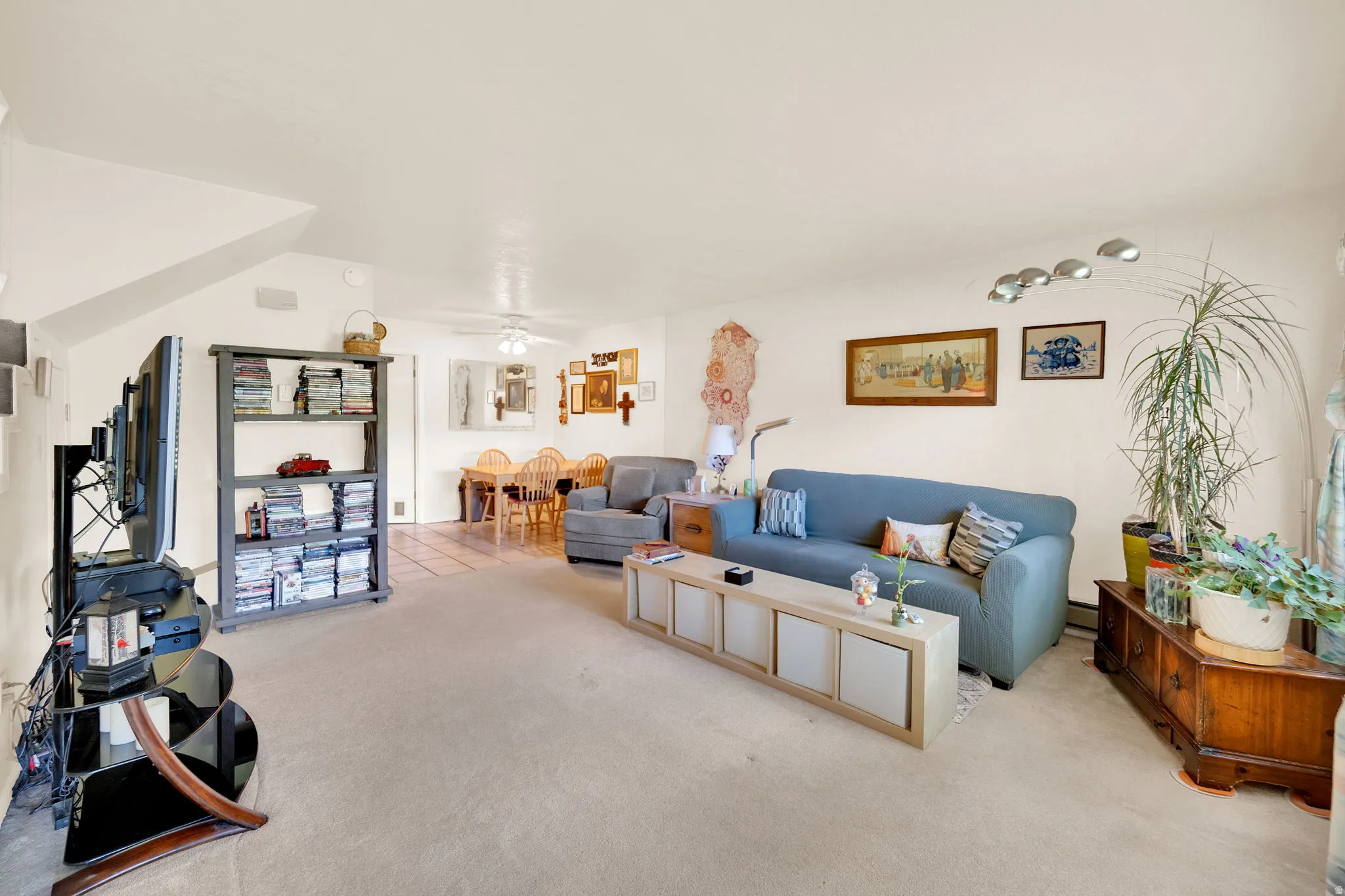 Living area featuring light colored carpet and ceiling fan