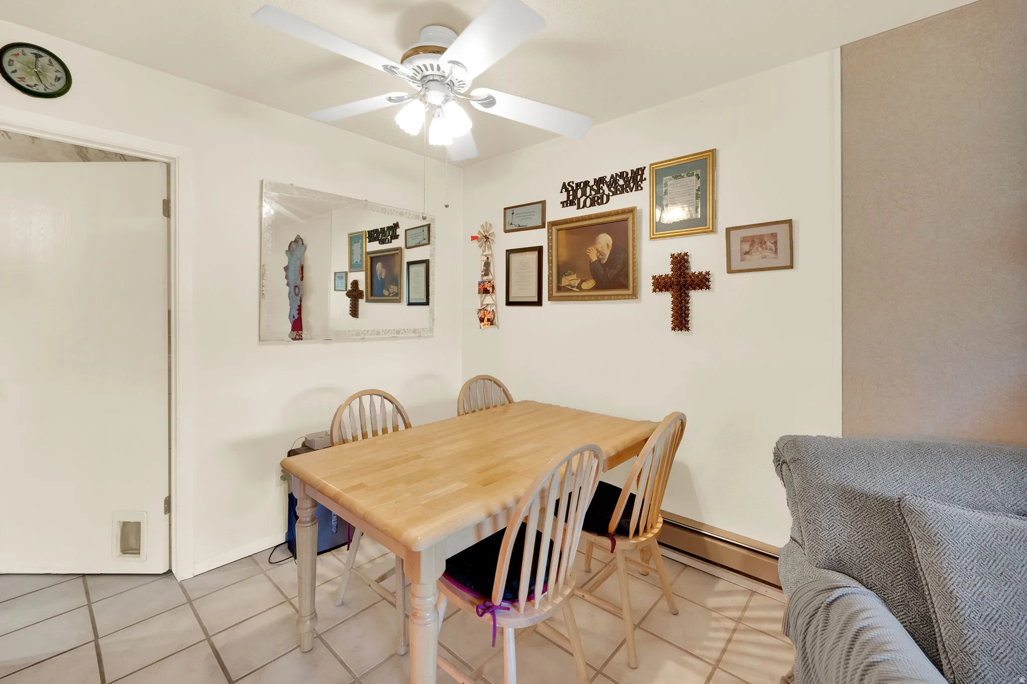 Dining room with a ceiling fan, a baseboard heating unit, and tile patterned floors