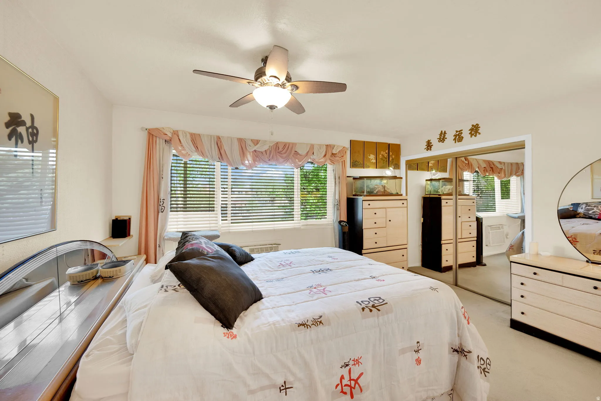 Bedroom with light carpet, a ceiling fan, and a closet