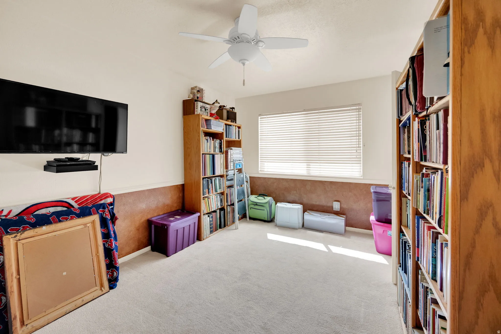 Game room with a ceiling fan and light colored carpet