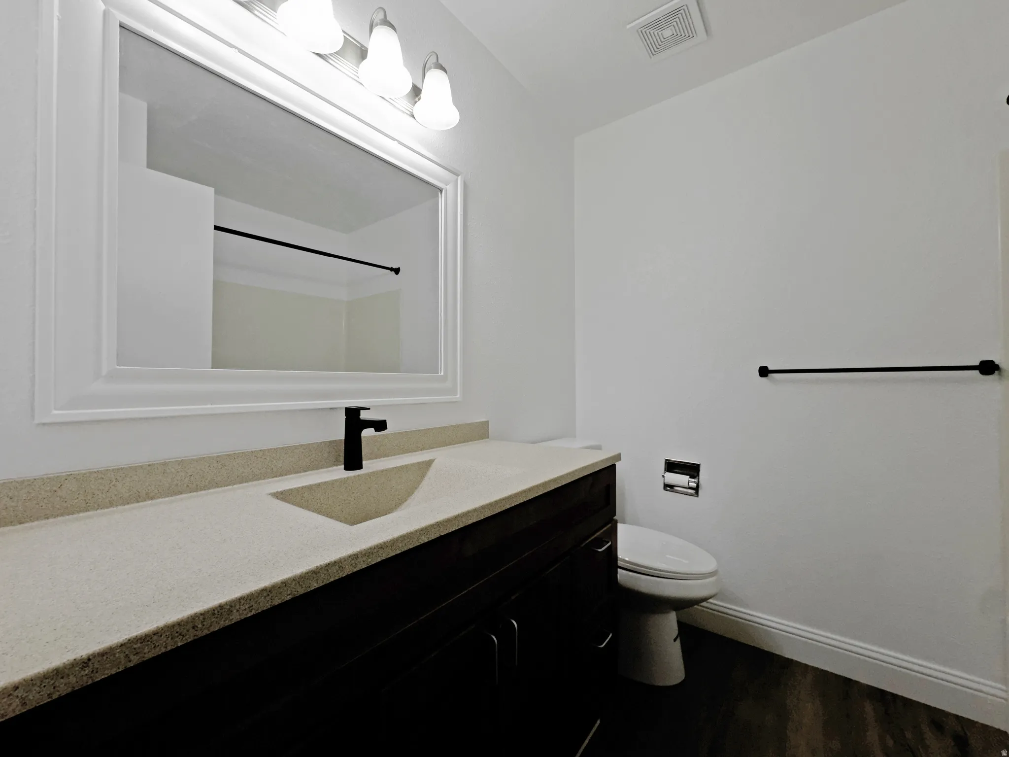 Bathroom featuring vanity and dark wood finished floors