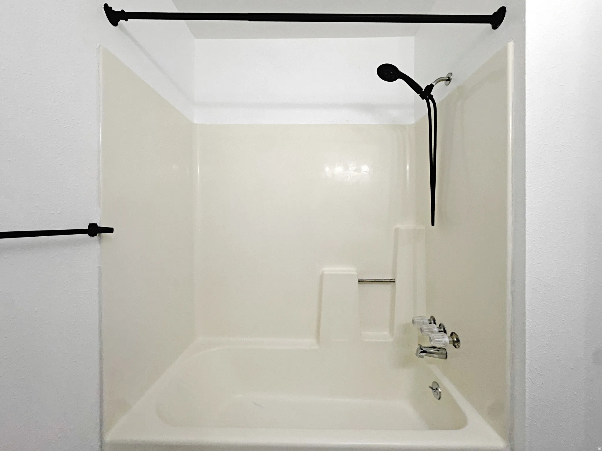 Full bath featuring shower / bathtub combination and a textured wall