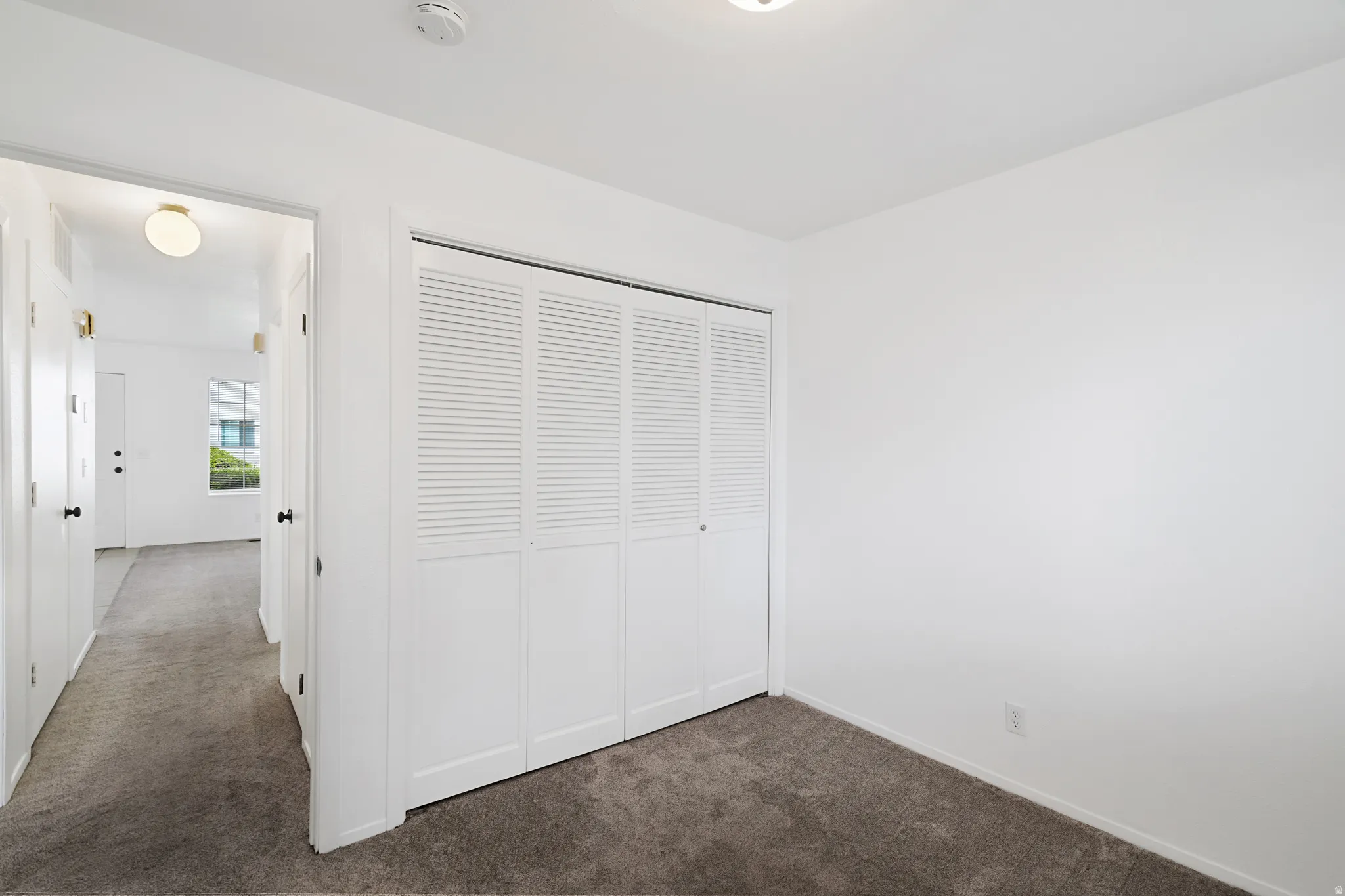 Secondary bedroom with dark carpet and a closet