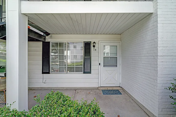 Entrance to property featuring brick siding and covered porch