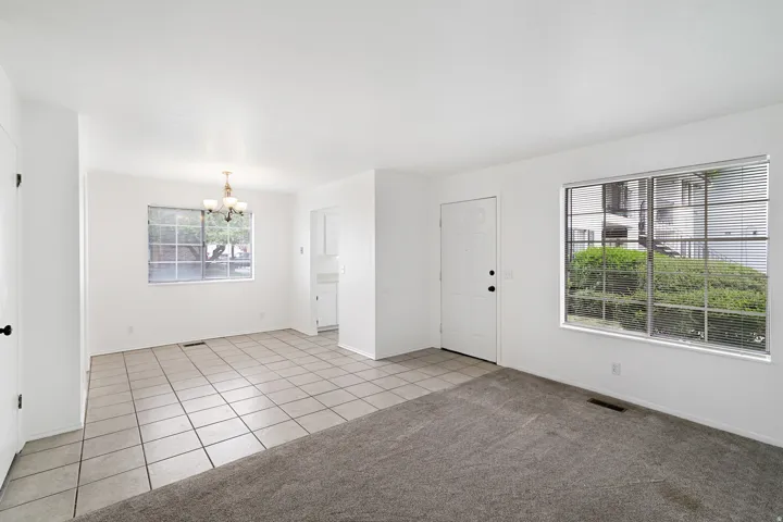 Dining area with a chandelier, light tile patterned flooring, and light colored carpet