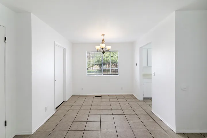 Dining area with suspended lighting and light tile patterned floors