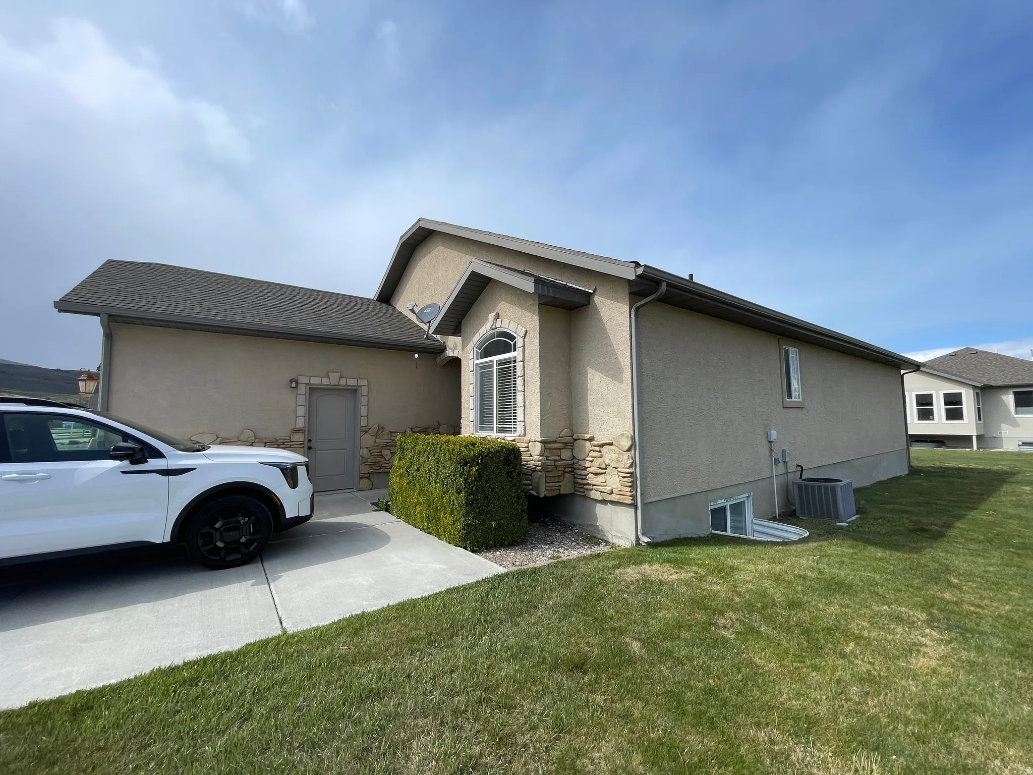 View of side of home with stucco siding and a lawn