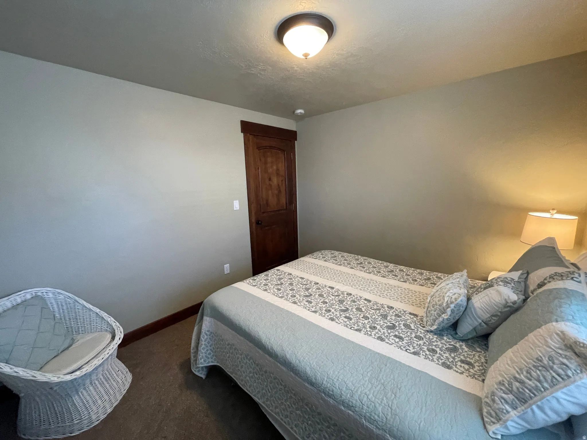 Bedroom featuring baseboards and dark carpet