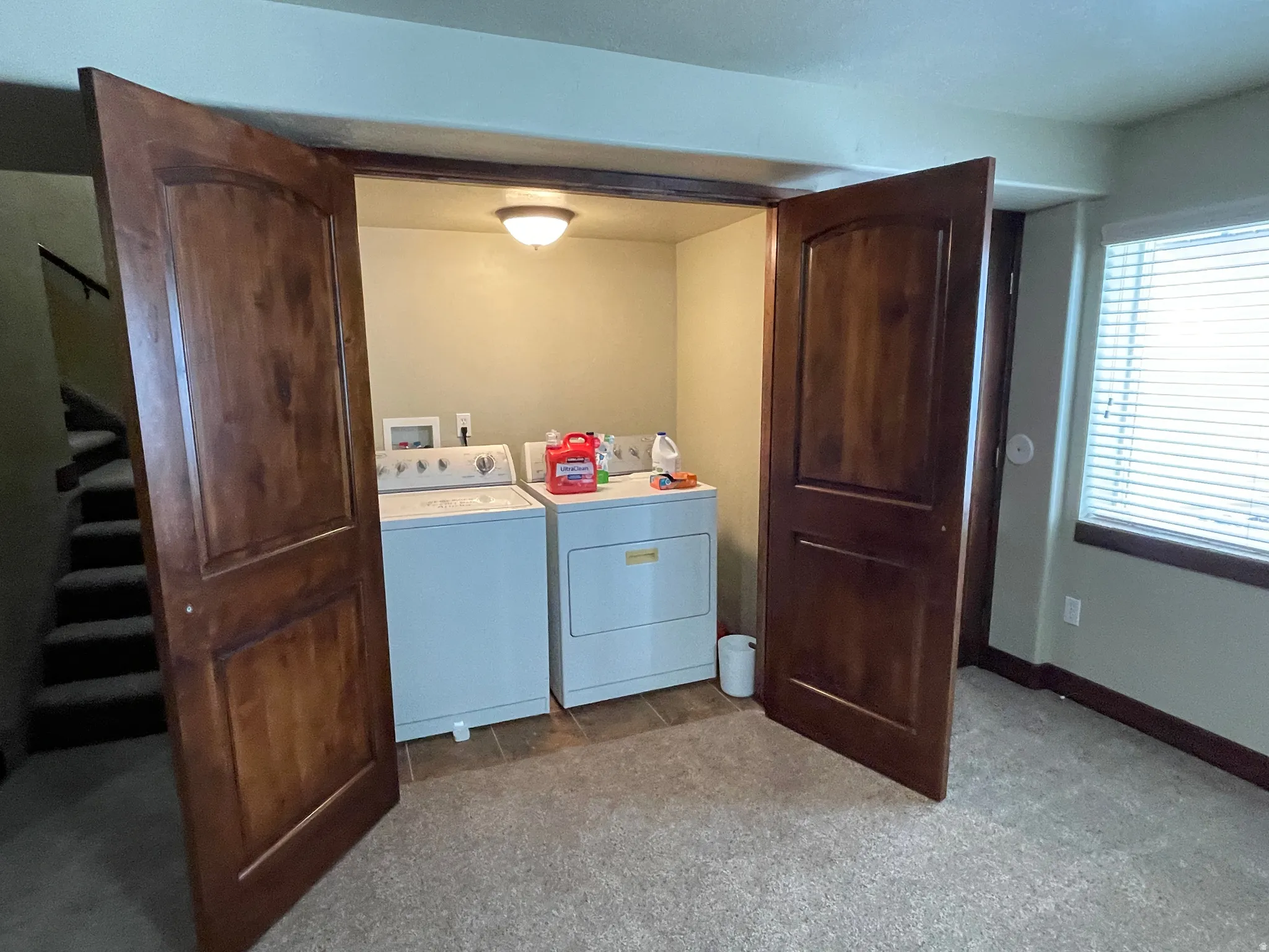 Laundry area featuring washing machine and dryer and carpet flooring