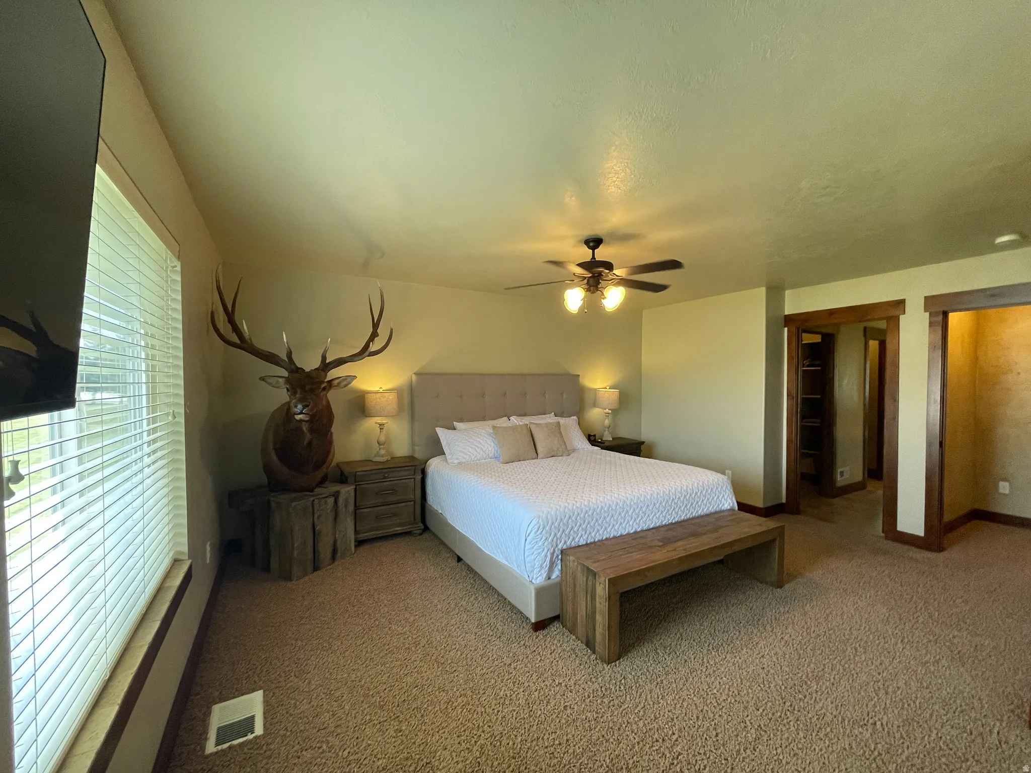 Carpeted bedroom featuring baseboards and ceiling fan