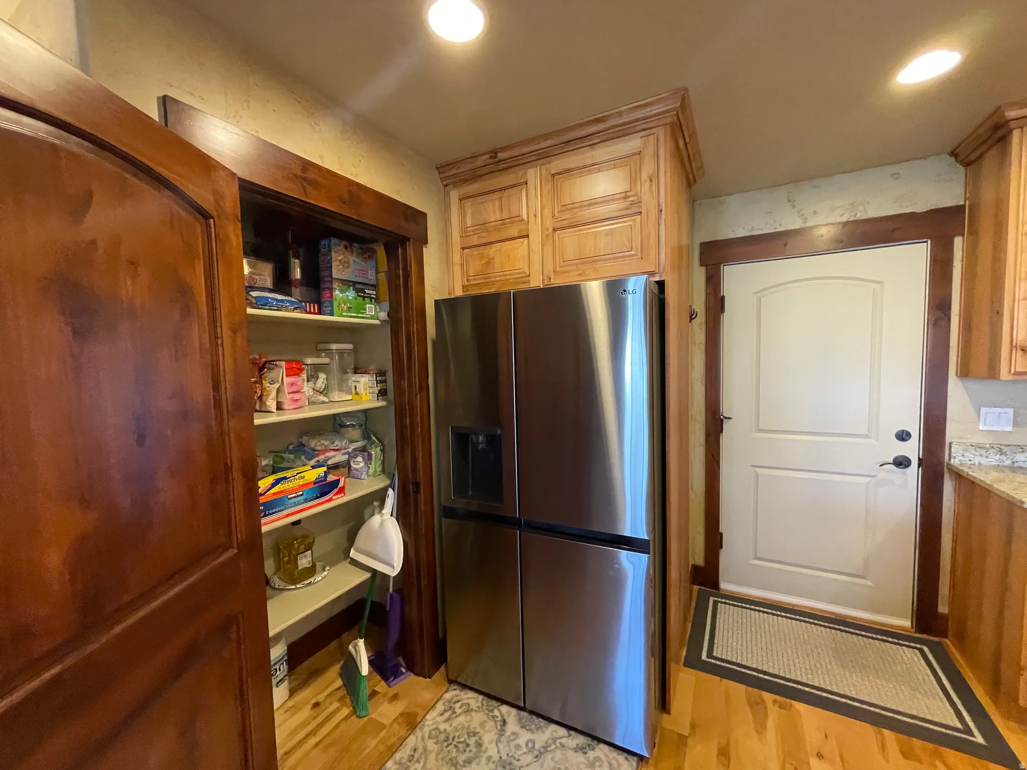 Kitchen featuring stainless steel fridge, light wood-style floors, and recessed lighting