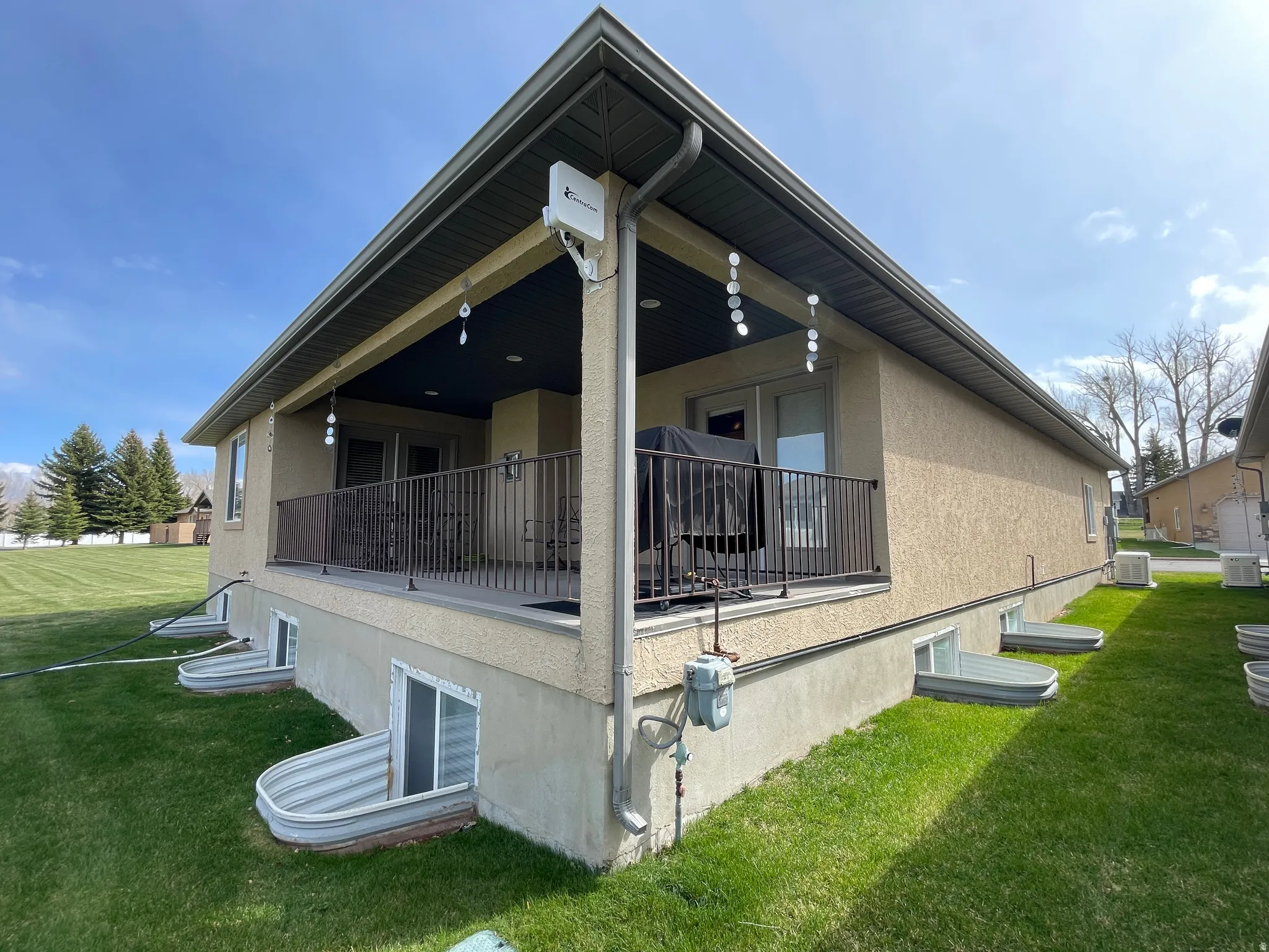 View of side of home with a yard, stucco siding, and a balcony