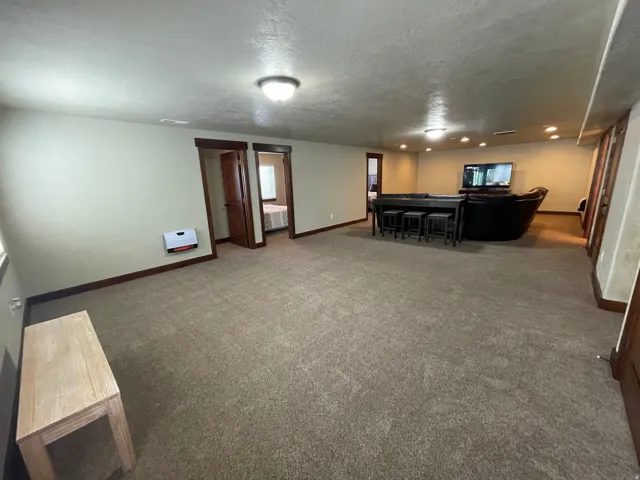 Living area with dark colored carpet and a textured ceiling