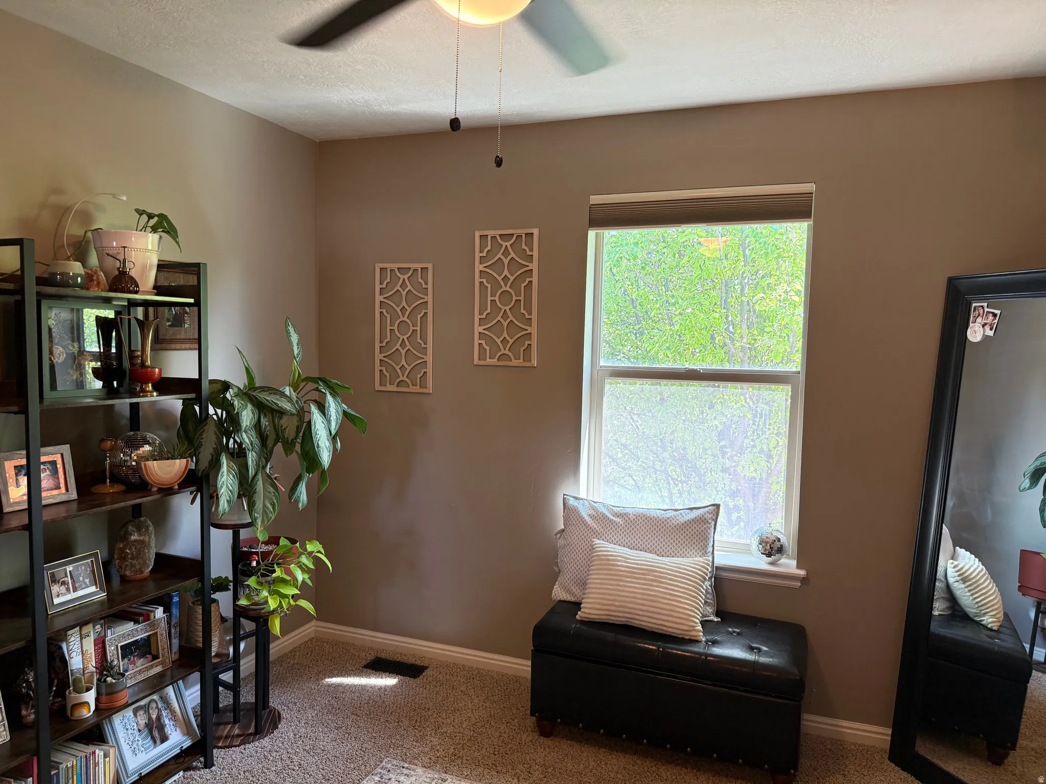 Living area with light colored carpet and ceiling fan