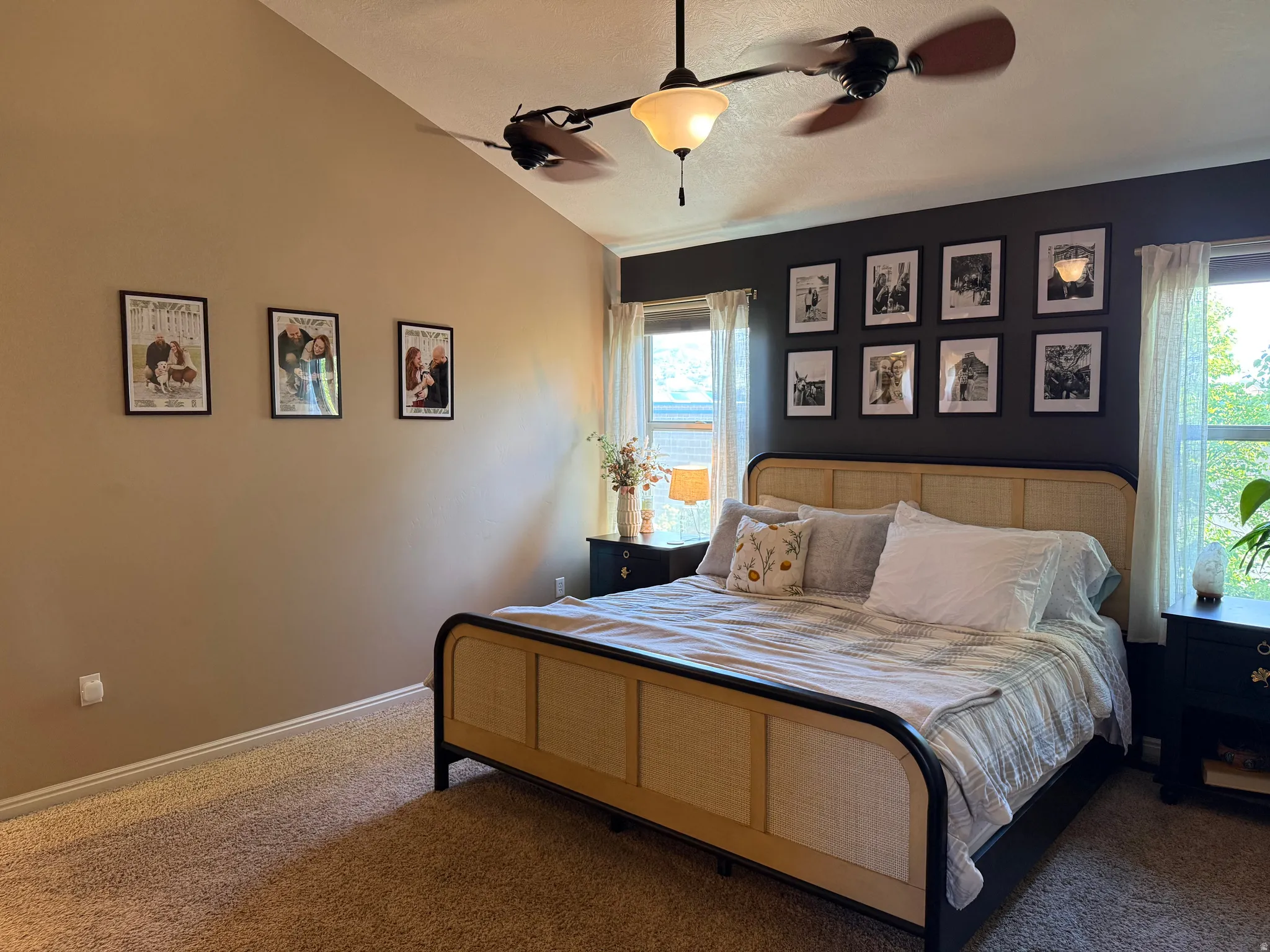 Carpeted bedroom with ceiling fan and lofted ceiling