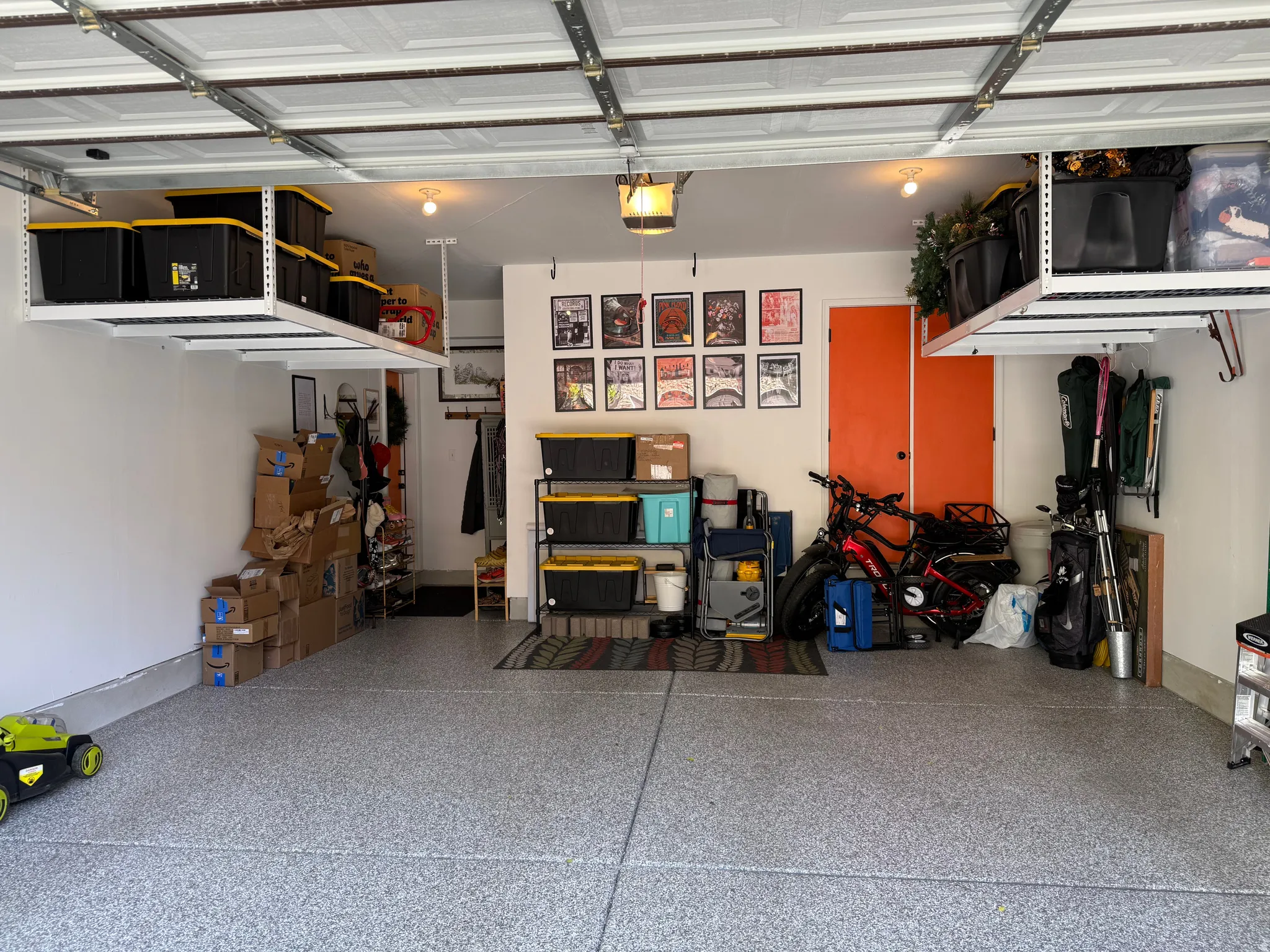 Garage featuring a garage door opener, epoxy flooring, and storage