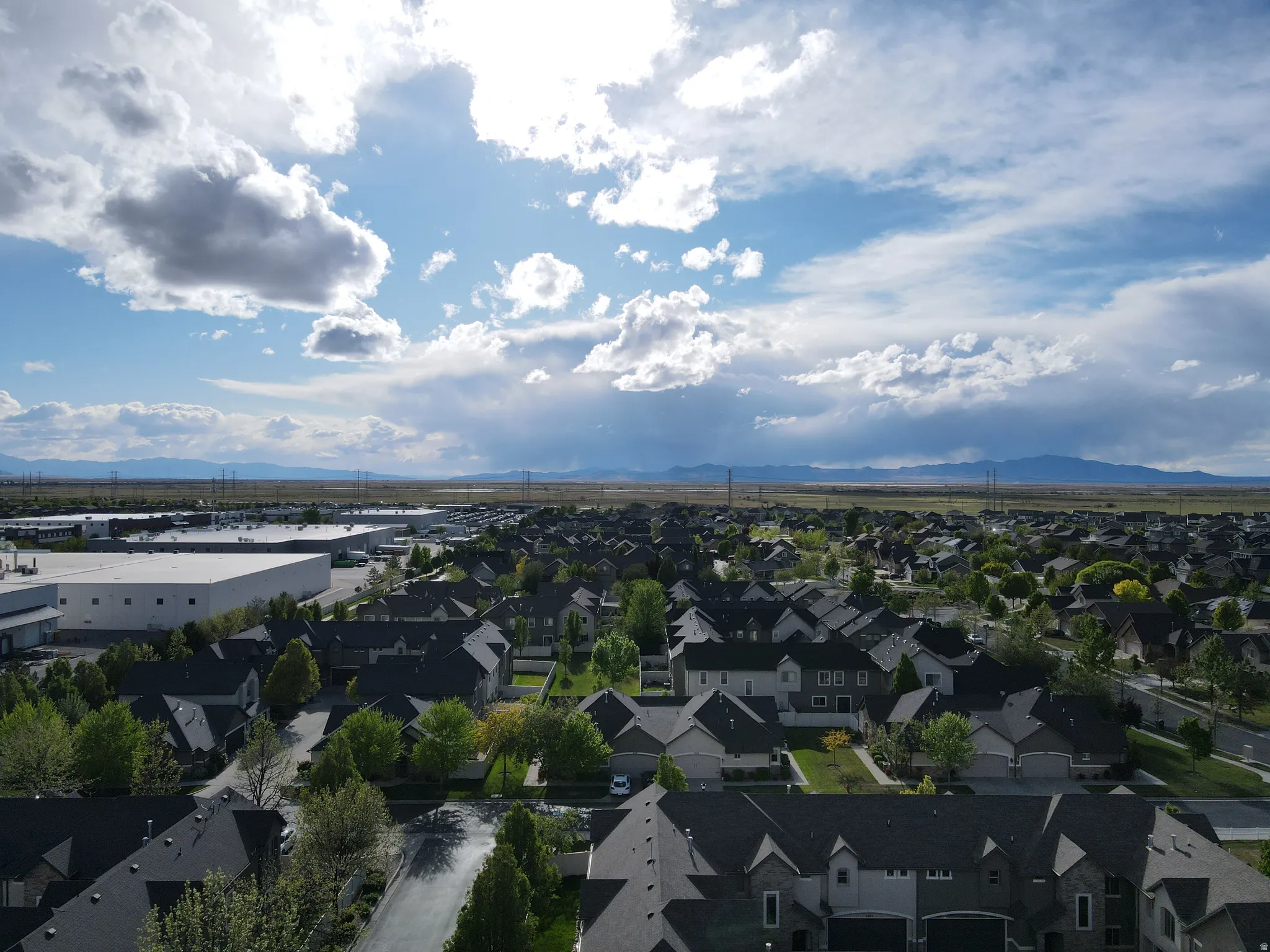 Aerial perspective looking west of suburban area featuring a mountainous background