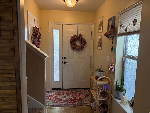 Foyer entrance featuring light tile patterned floors