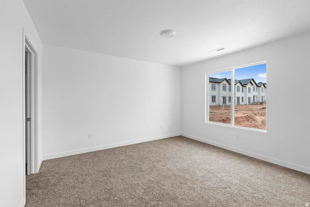 Carpeted empty room featuring baseboards