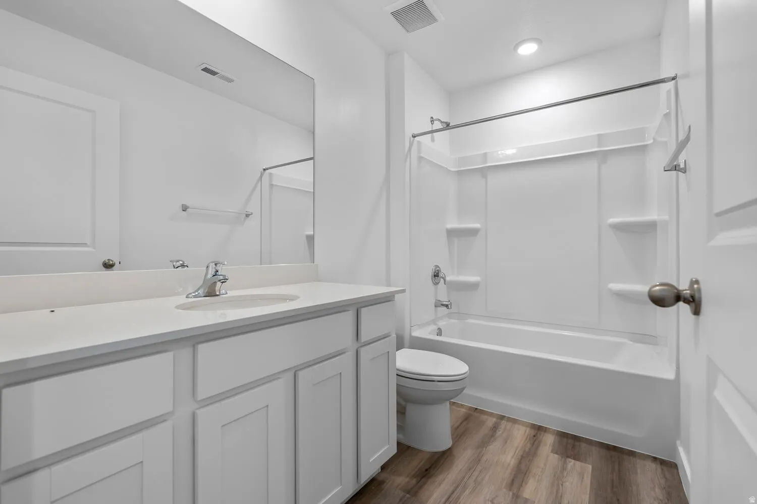 Bathroom featuring vanity, dark wood-style floors, and bathing tub / shower combination