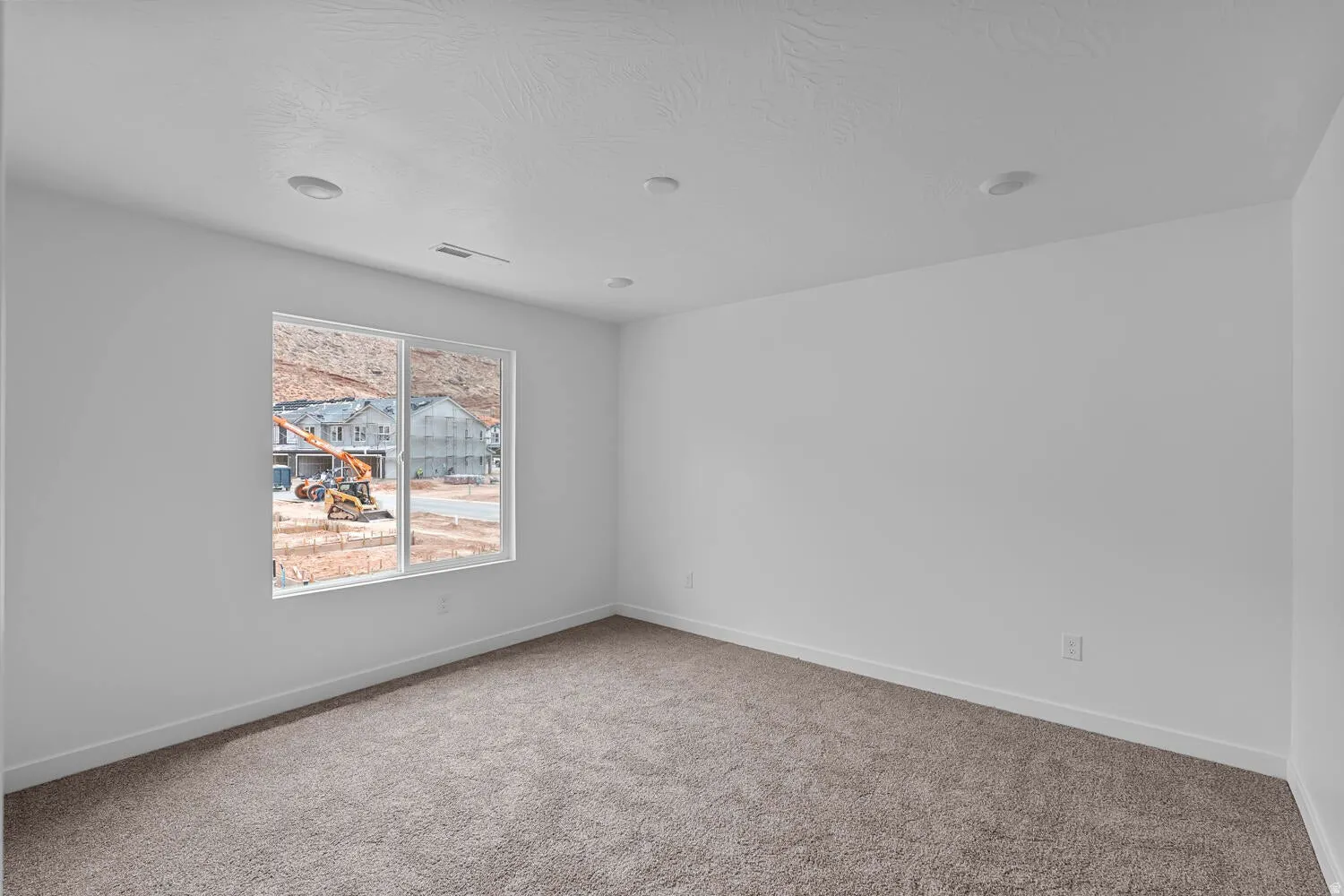 Carpeted spare room featuring baseboards