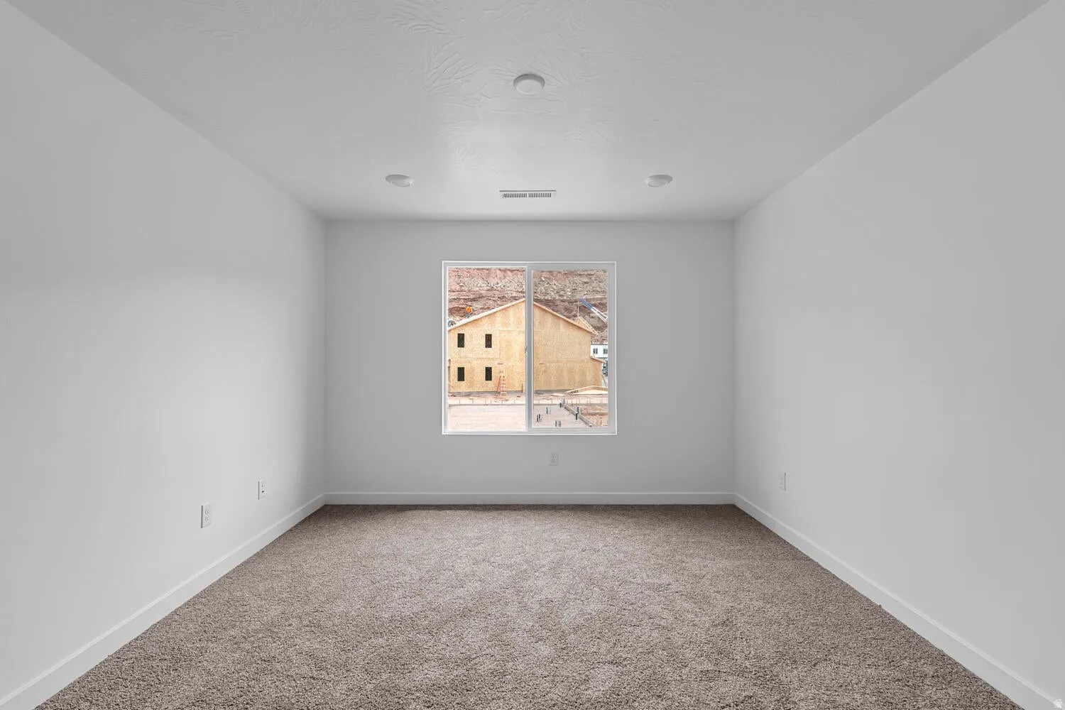 Carpeted spare room with baseboards
