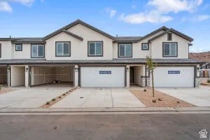 Traditional-style home featuring an attached garage and driveway