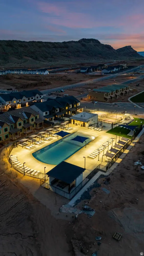 Pool at dusk with a community pool, a mountain view, and a patio area