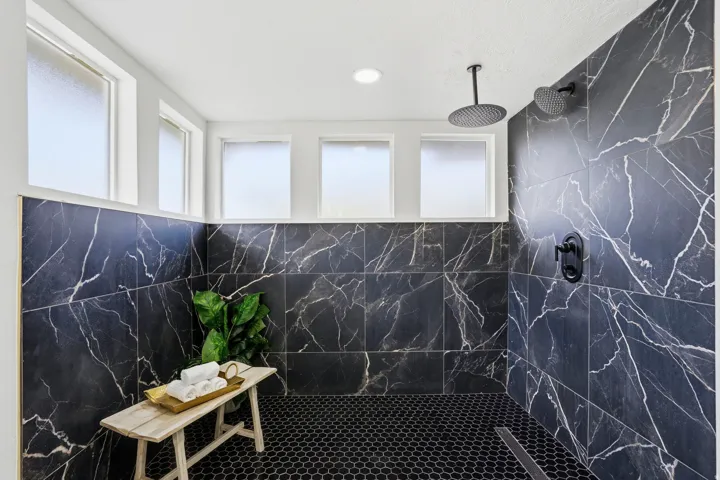 Bathroom featuring a marble finish shower and pet washing area