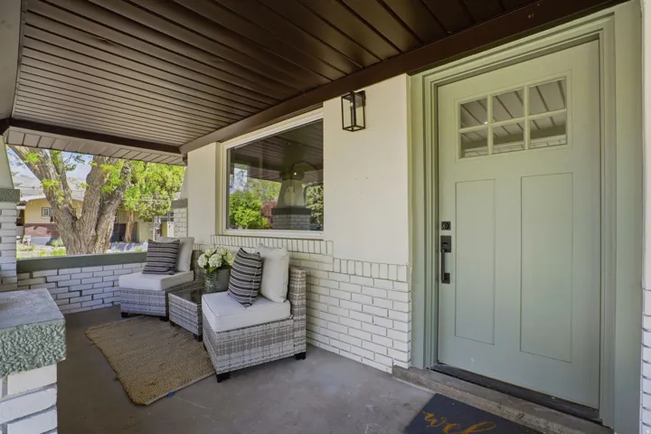 Entrance to property featuring brick siding and a patio