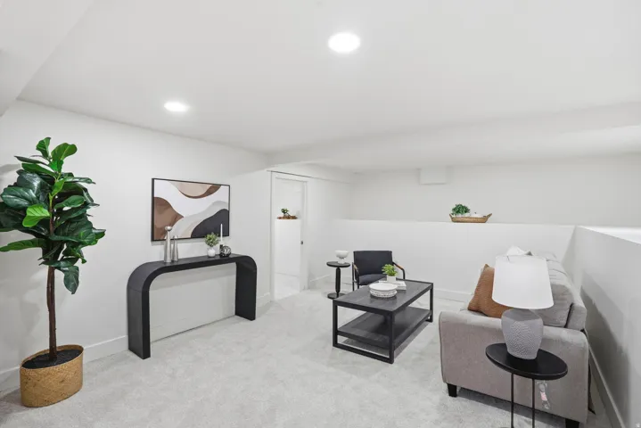 Living area with light carpet and recessed lighting