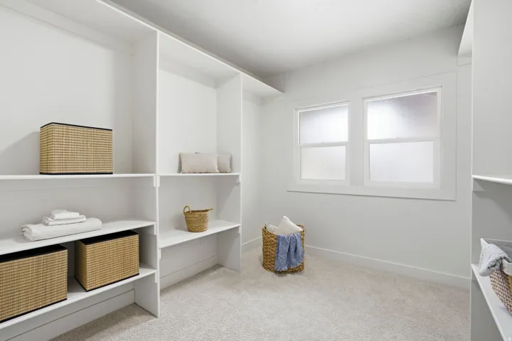 Walk in closet featuring light colored carpet