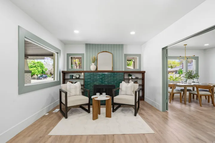 Living area featuring a brick fireplace, light wood-style flooring, and recessed lighting
