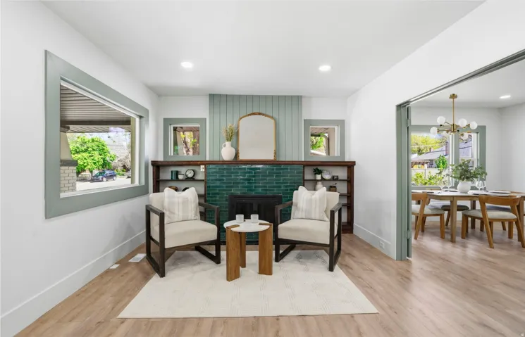 Living area featuring a fireplace with teal tile surround and shiplap accent wall, built-in shelving, light wood-finish flooring, and recessed lighting