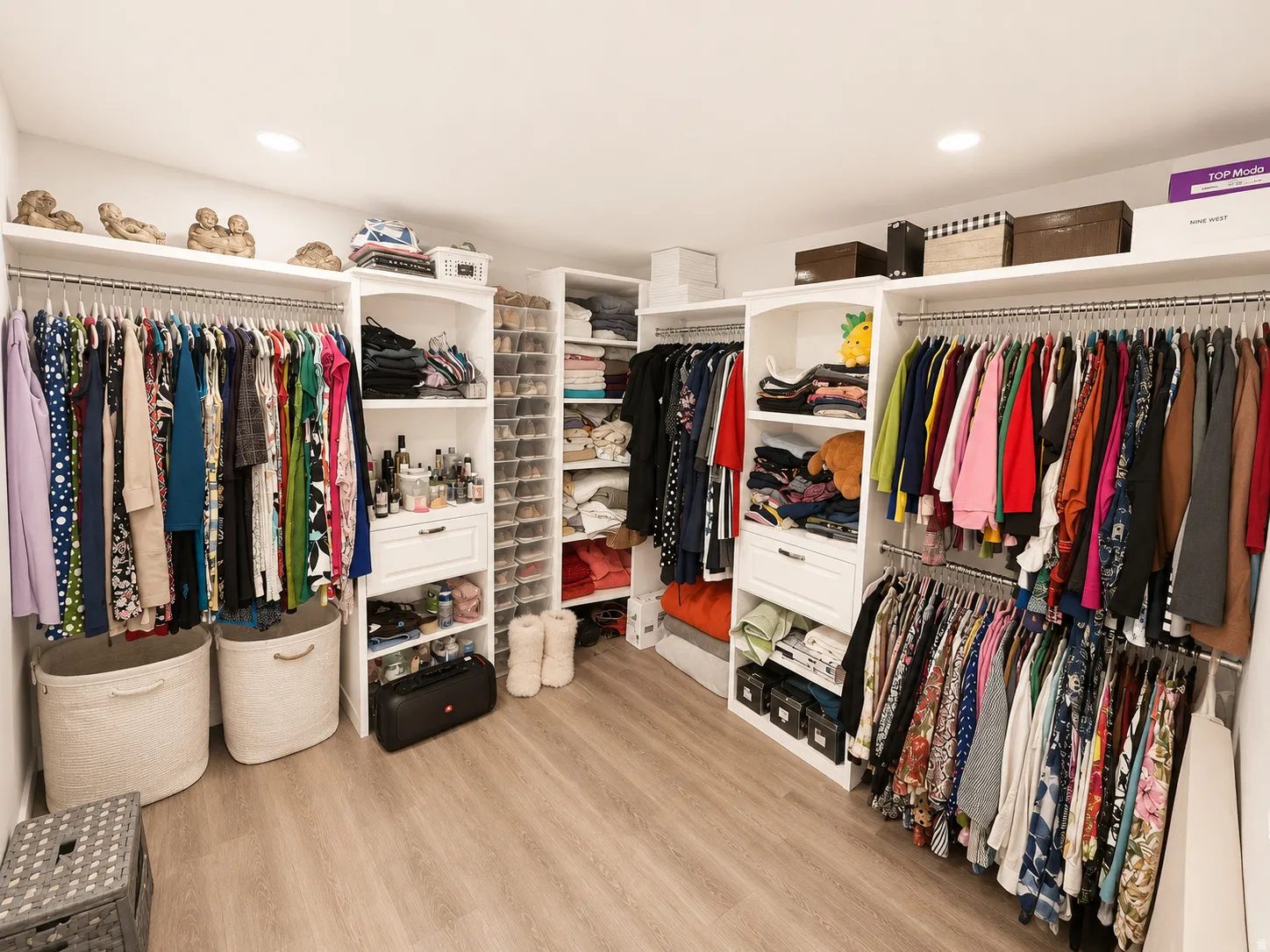 Custom closet system featuring wood-finish flooring, recessed lighting, multiple hanging rods, integrated shelving, and dedicated shoe storage