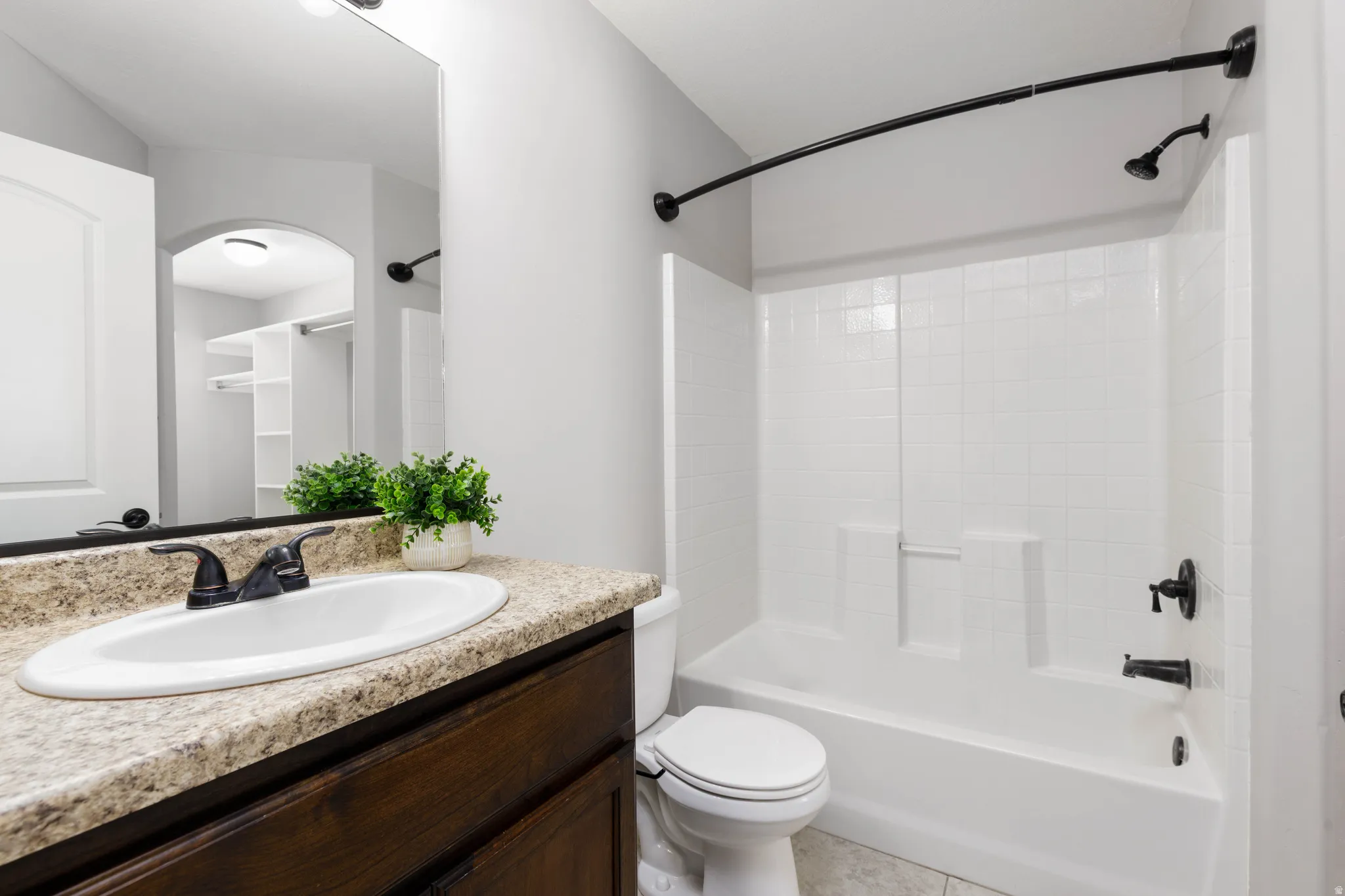 Primary bathroom featuring vanity, shower / washtub combination, and granite counter