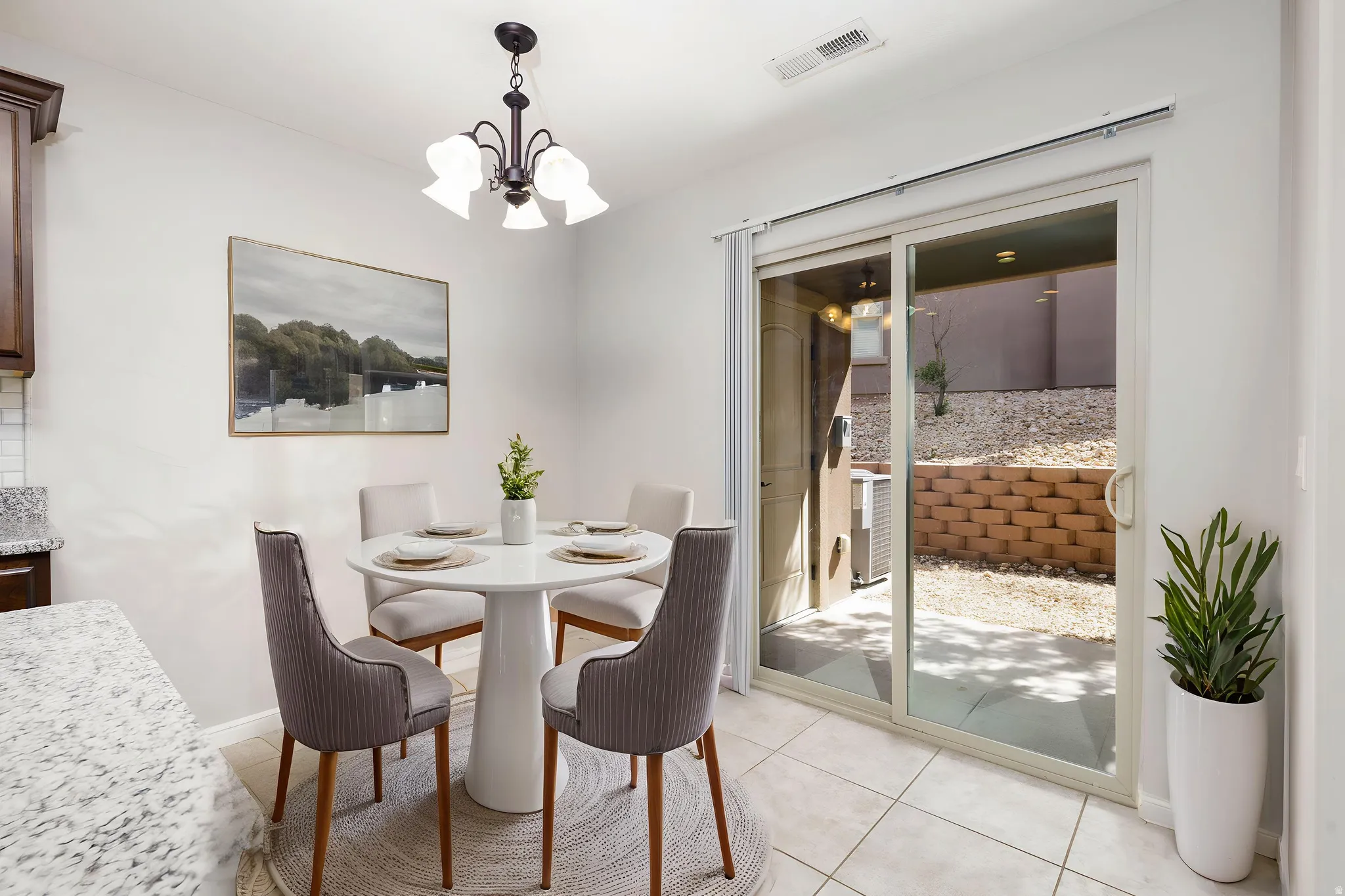 Dining space featuring hanging lights and light tile floors. virtual staging
