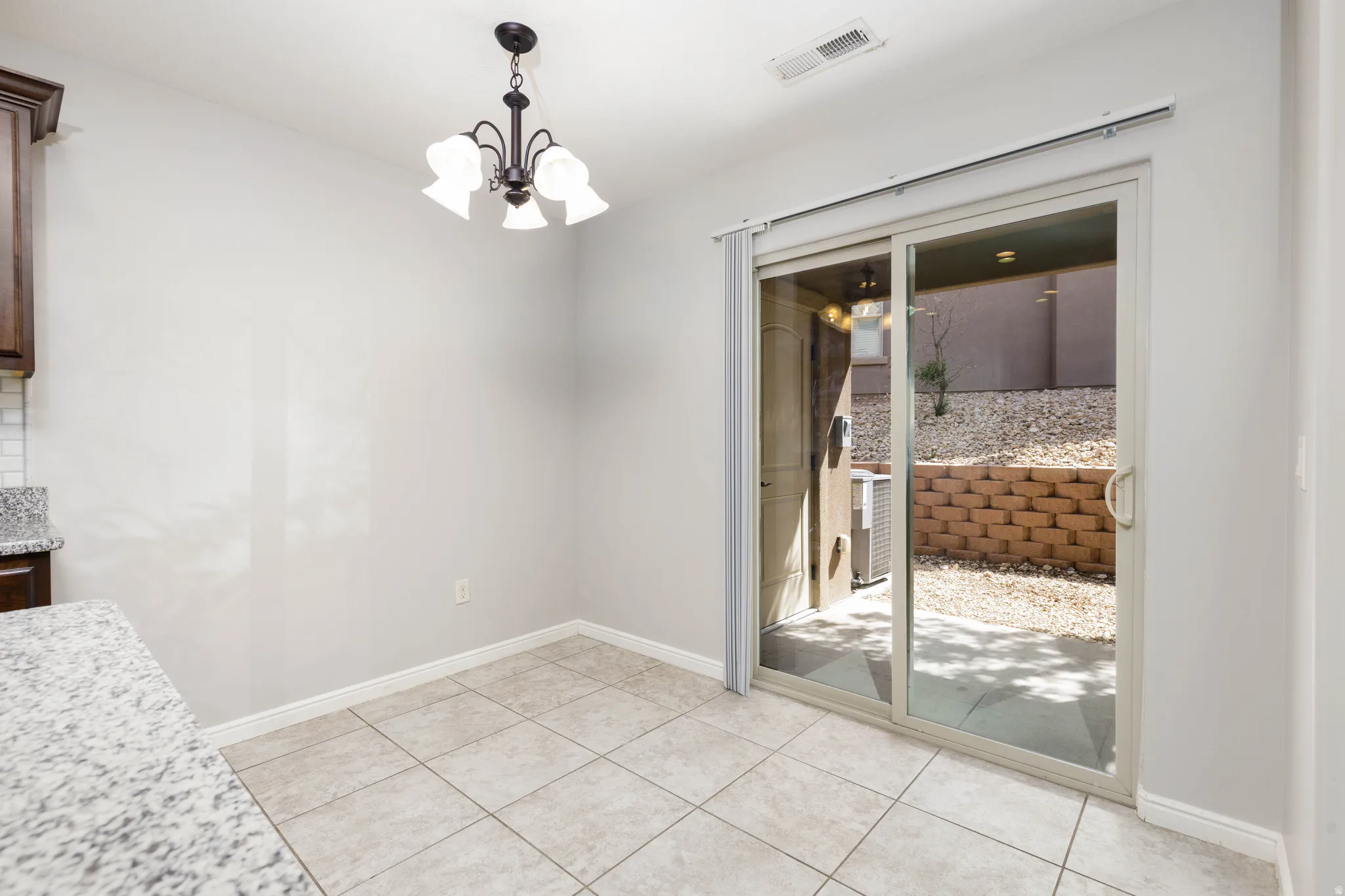 Dining area with suspended lighting and light tile flooring